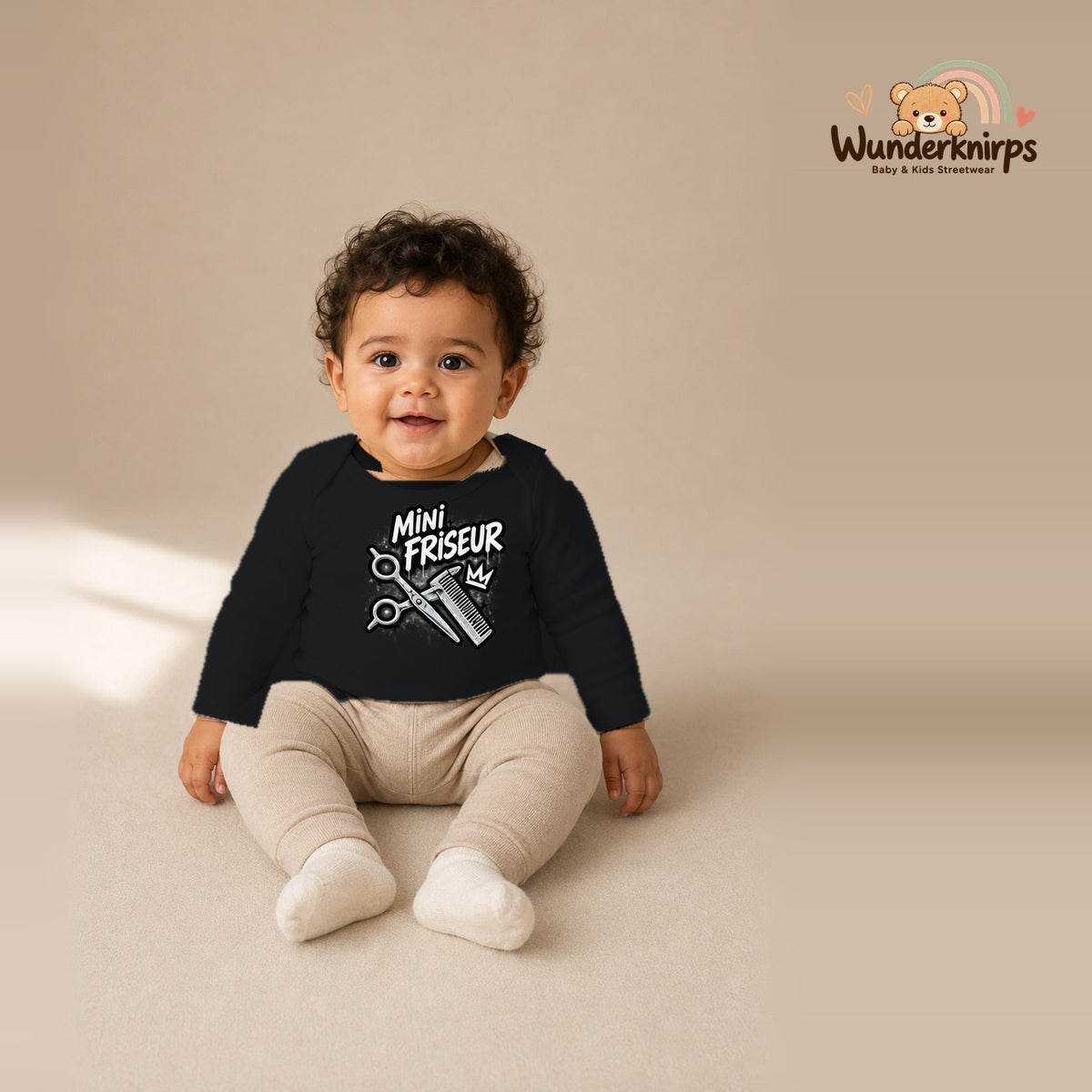 Babybody für Jungen in Schwarz mit Motiv „Mini Friseur“, getragen von einem Kind – Wunderknirps.
