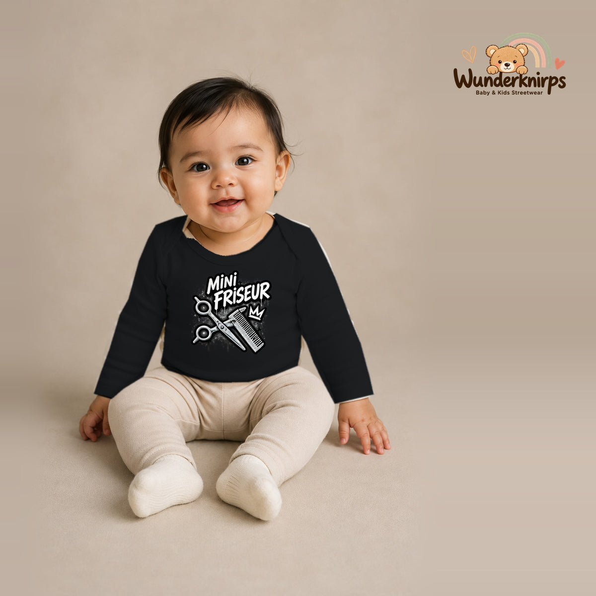 Babybody für Mädchen in Schwarz mit Motiv „Mini Friseur“, getragen von einem Kind – Wunderknirps.