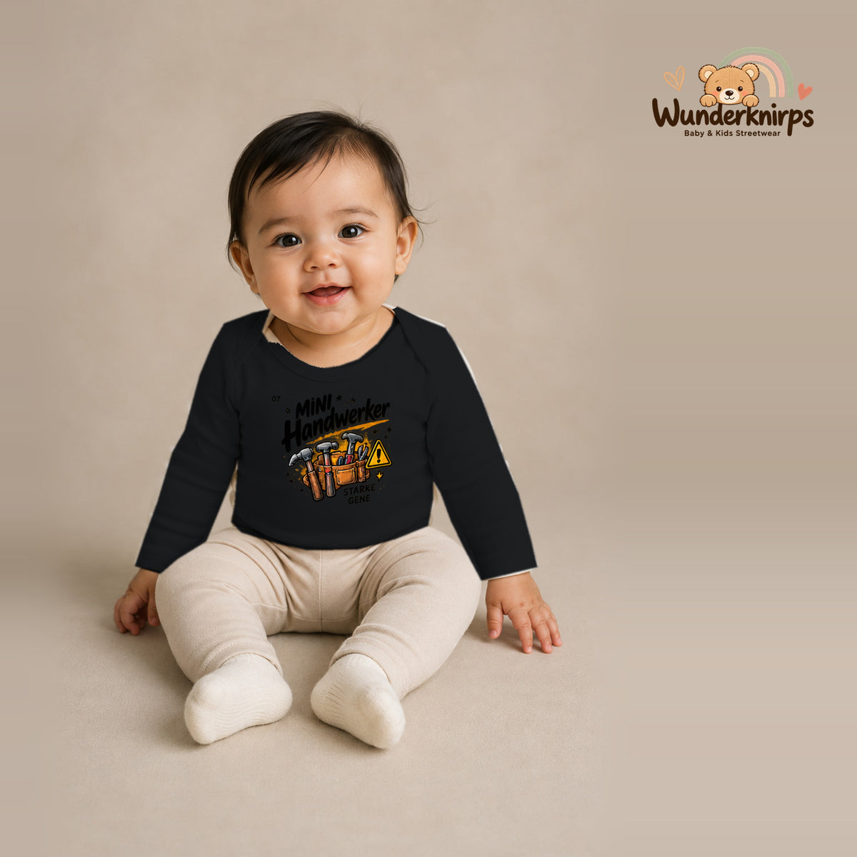 Babybody für Mädchen in Schwarz mit Motiv „Mini Handwerker“, getragen von einem Kind – Wunderknirps.