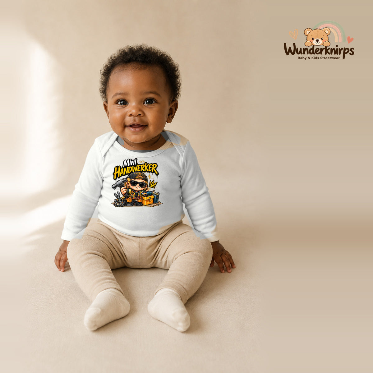 Babybody für Mädchen in Weiß mit Motiv „Mini Handwerker“, getragen von einem Kind – Wunderknirps.