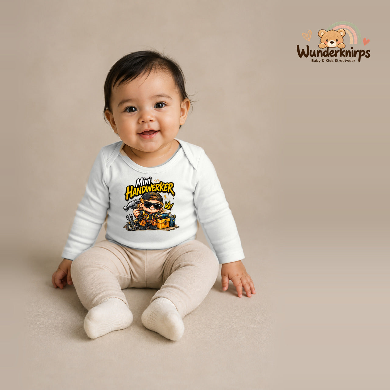 Babybody für Mädchen in Weiß mit Motiv „Mini Handwerker“, getragen von einem Kind – Wunderknirps.