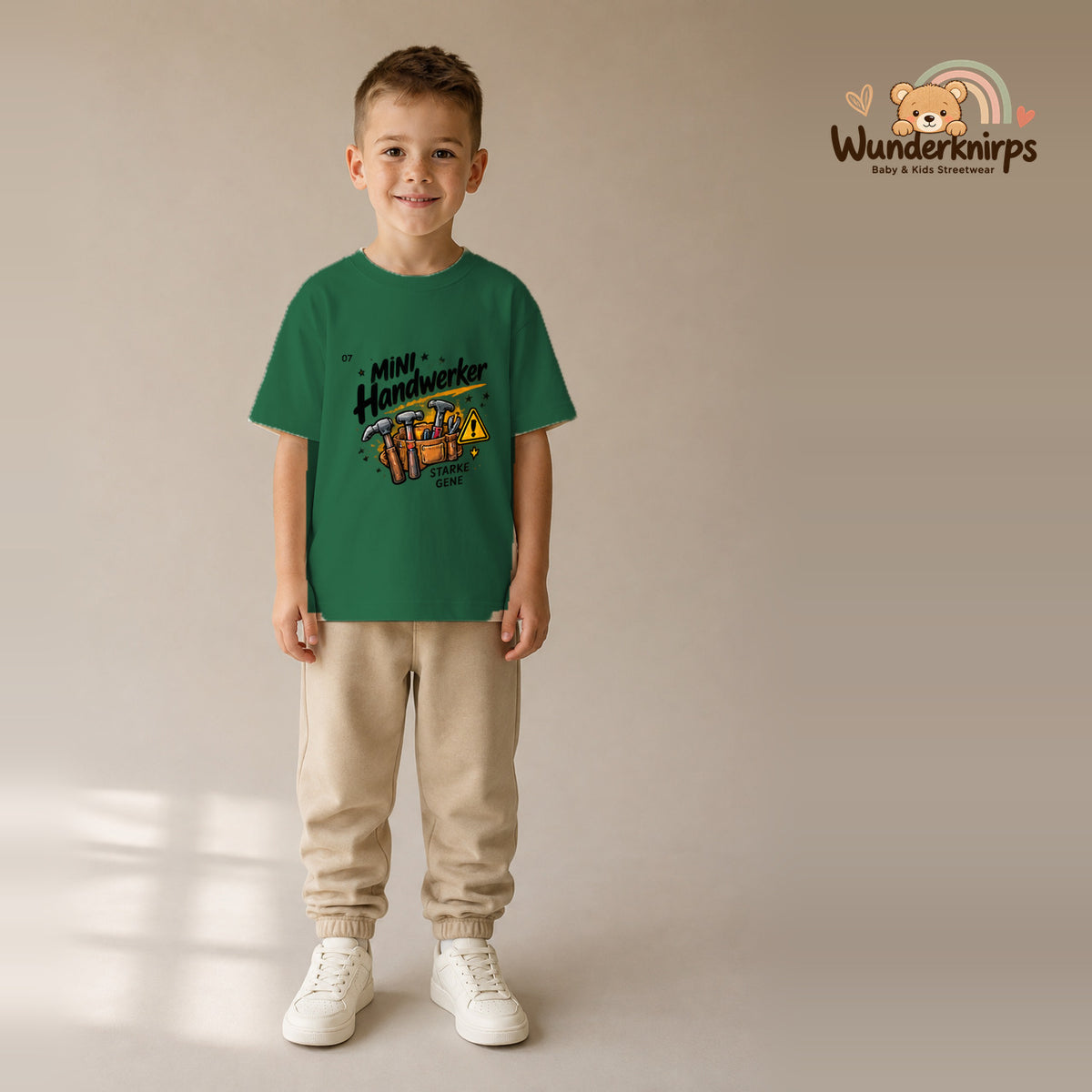 T-Shirt für Jungen in Grün mit Motiv „Mini Handwerker“, getragen von einem Kind – Wunderknirps.