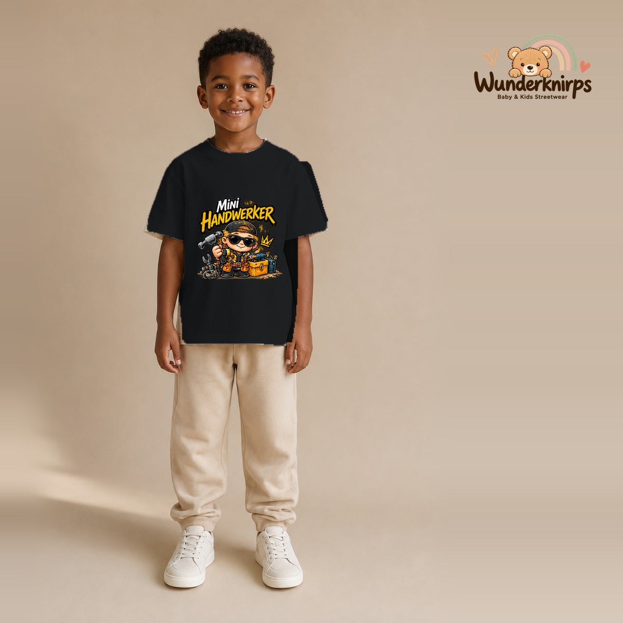 T-Shirt für Jungen in Schwarz mit Motiv „Mini Handwerker“, getragen von einem Kind – Wunderknirps.