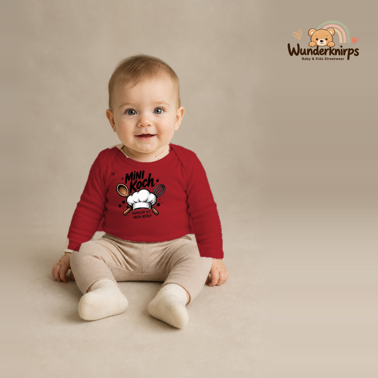 Babybody für Jungen in Rot mit Motiv „Mini Koch“, getragen von einem Kind – Wunderknirps.
