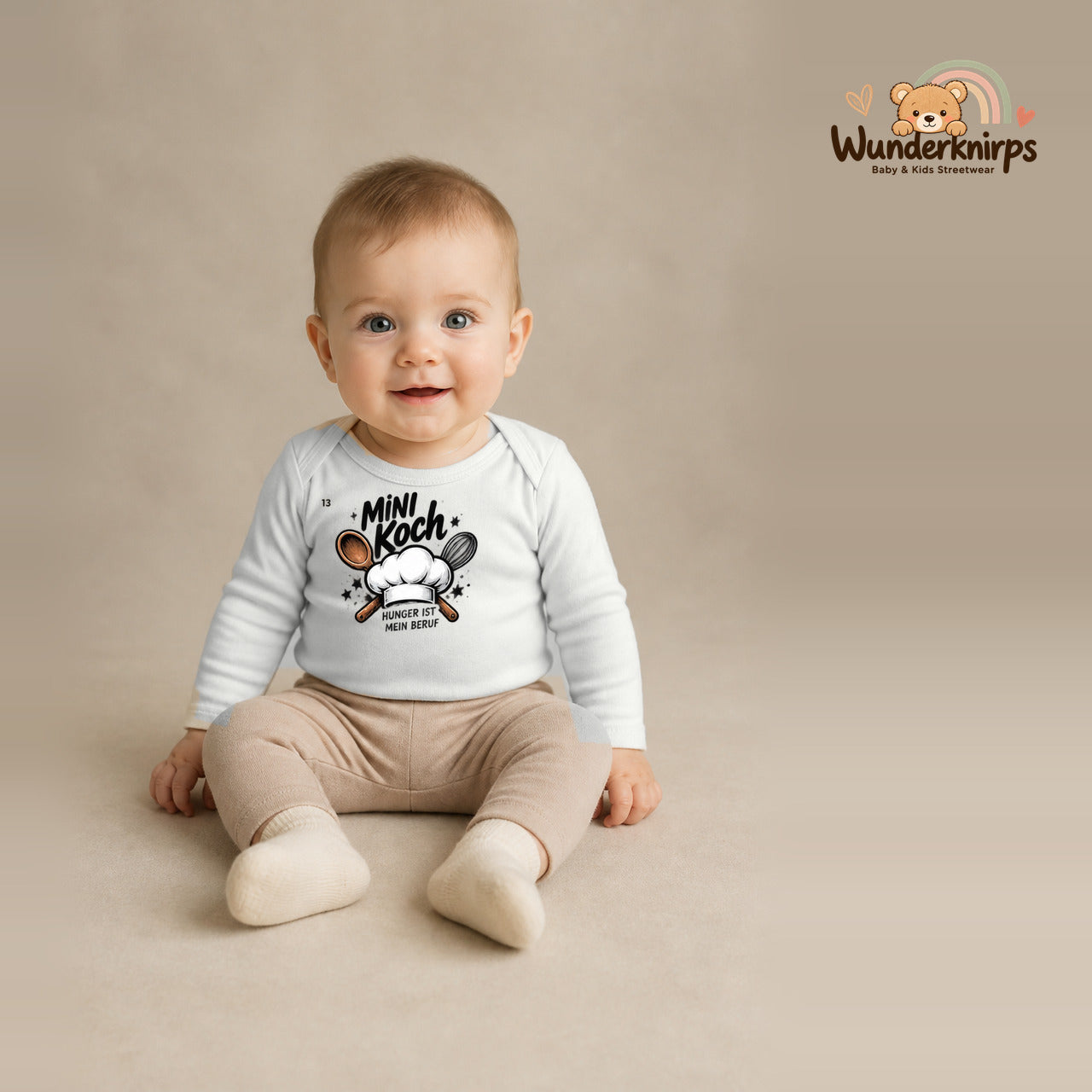 Babybody für Jungen in Weiß mit Motiv „Mini Koch“, getragen von einem Kind – Wunderknirps.