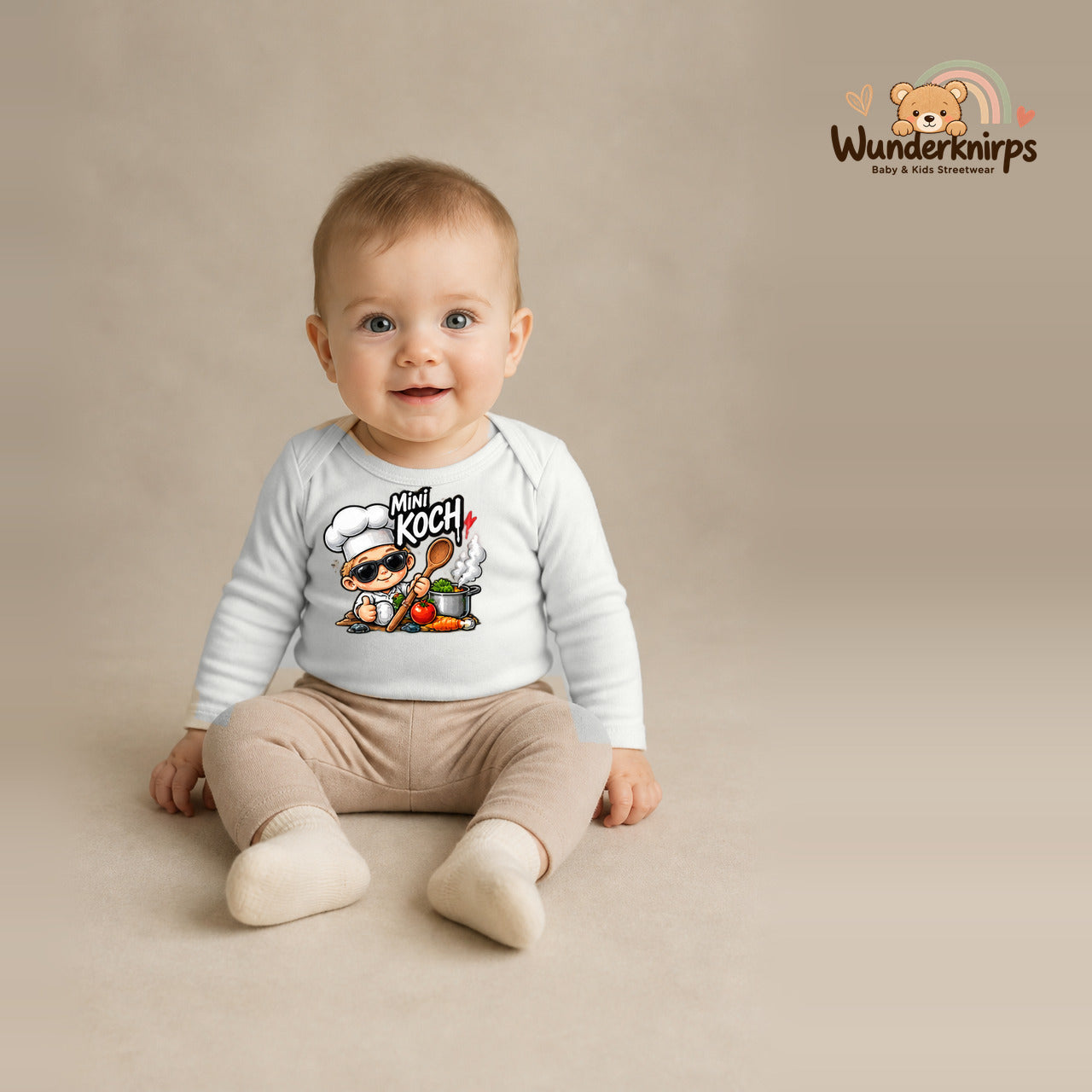 Babybody für Jungen in Weiß mit Motiv „Mini Koch“, getragen von einem Kind – Wunderknirps.