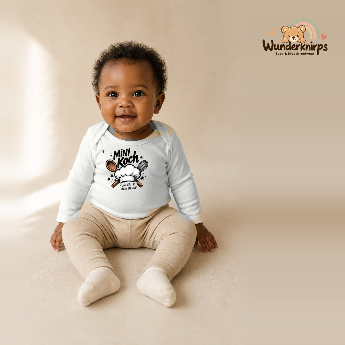 Babybody für Mädchen in Weiß mit Motiv „Mini Koch“, getragen von einem Kind – Wunderknirps.