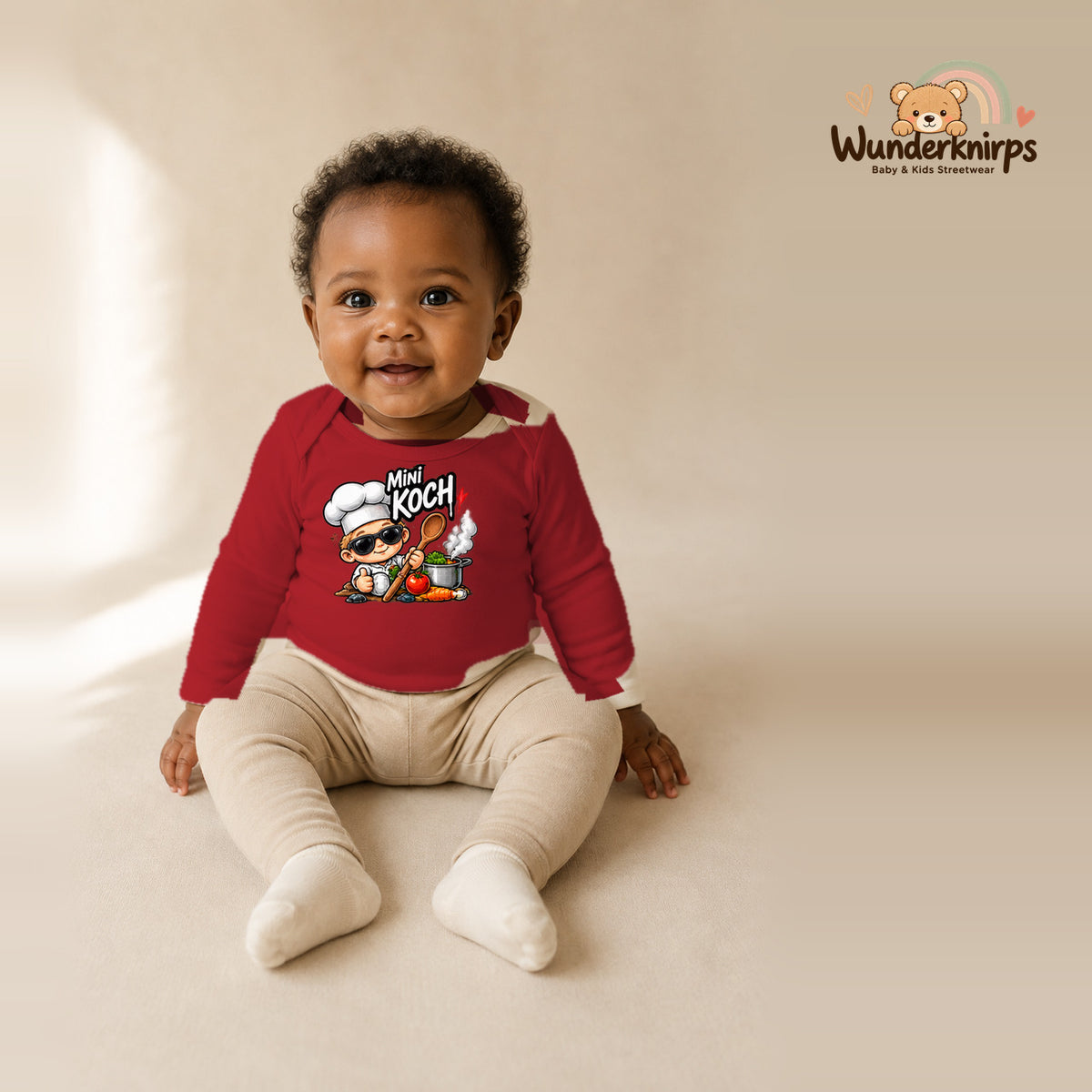 Babybody für Mädchen in Rot mit Motiv „Mini Koch“, getragen von einem Kind – Wunderknirps.