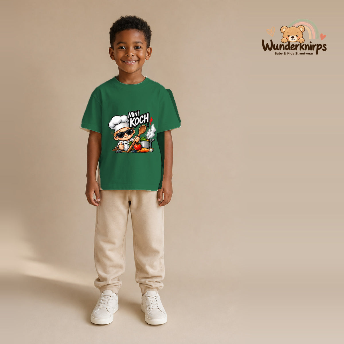 T-Shirt für Jungen in Grün mit Motiv „Mini Koch“, getragen von einem Kind – Wunderknirps.
