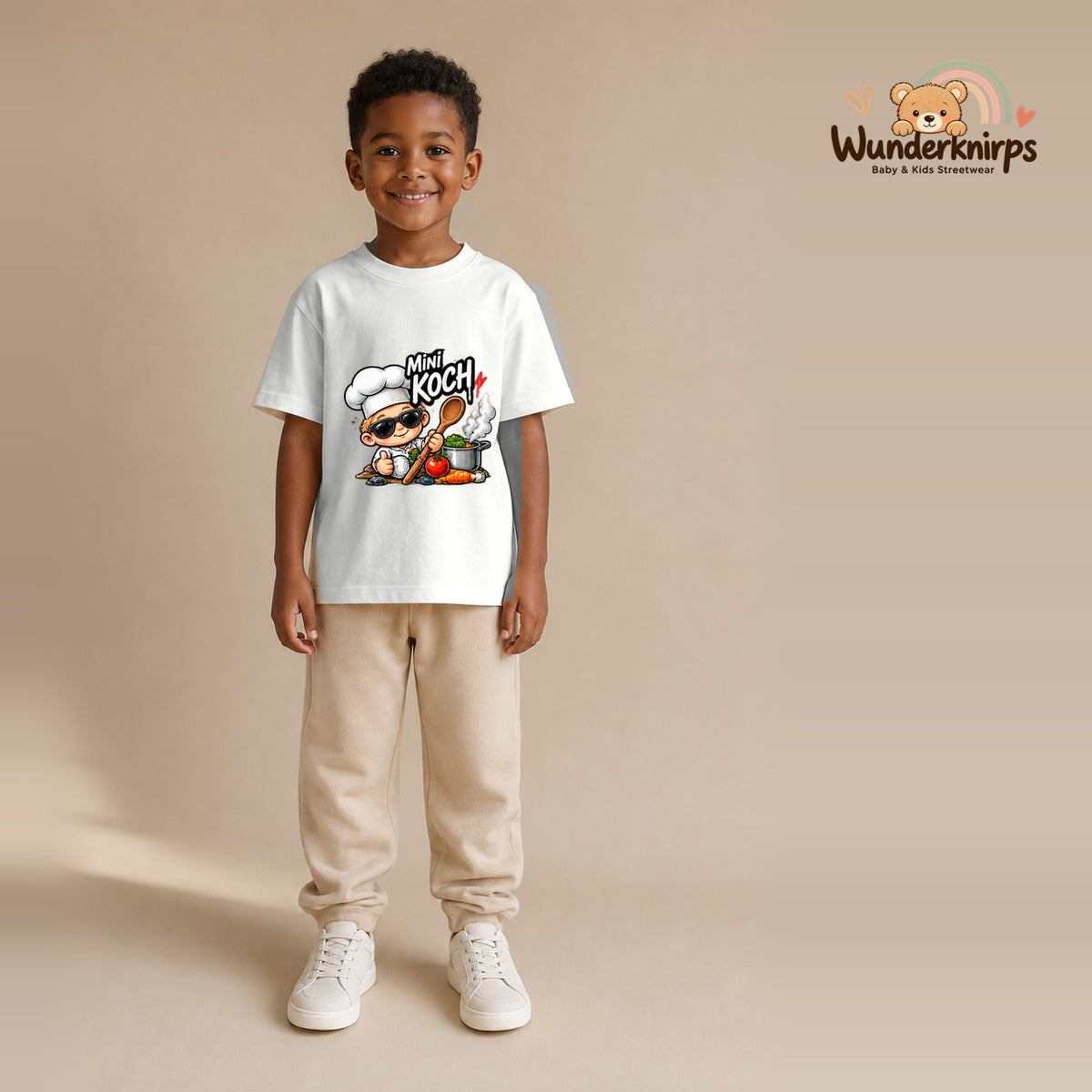 T-Shirt für Jungen in Weiß mit Motiv „Mini Koch“, getragen von einem Kind – Wunderknirps.