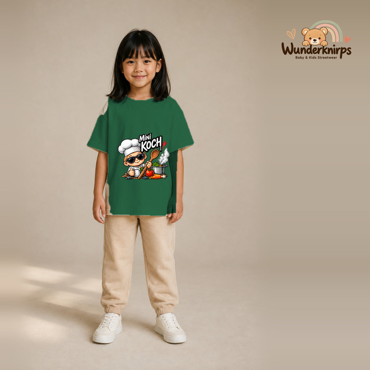 T-Shirt für Mädchen in Grün mit Motiv „Mini Koch“, getragen von einem Kind – Wunderknirps.