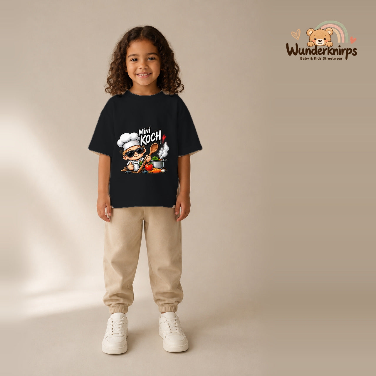 T-Shirt für Mädchen in Schwarz mit Motiv „Mini Koch“, getragen von einem Kind – Wunderknirps.