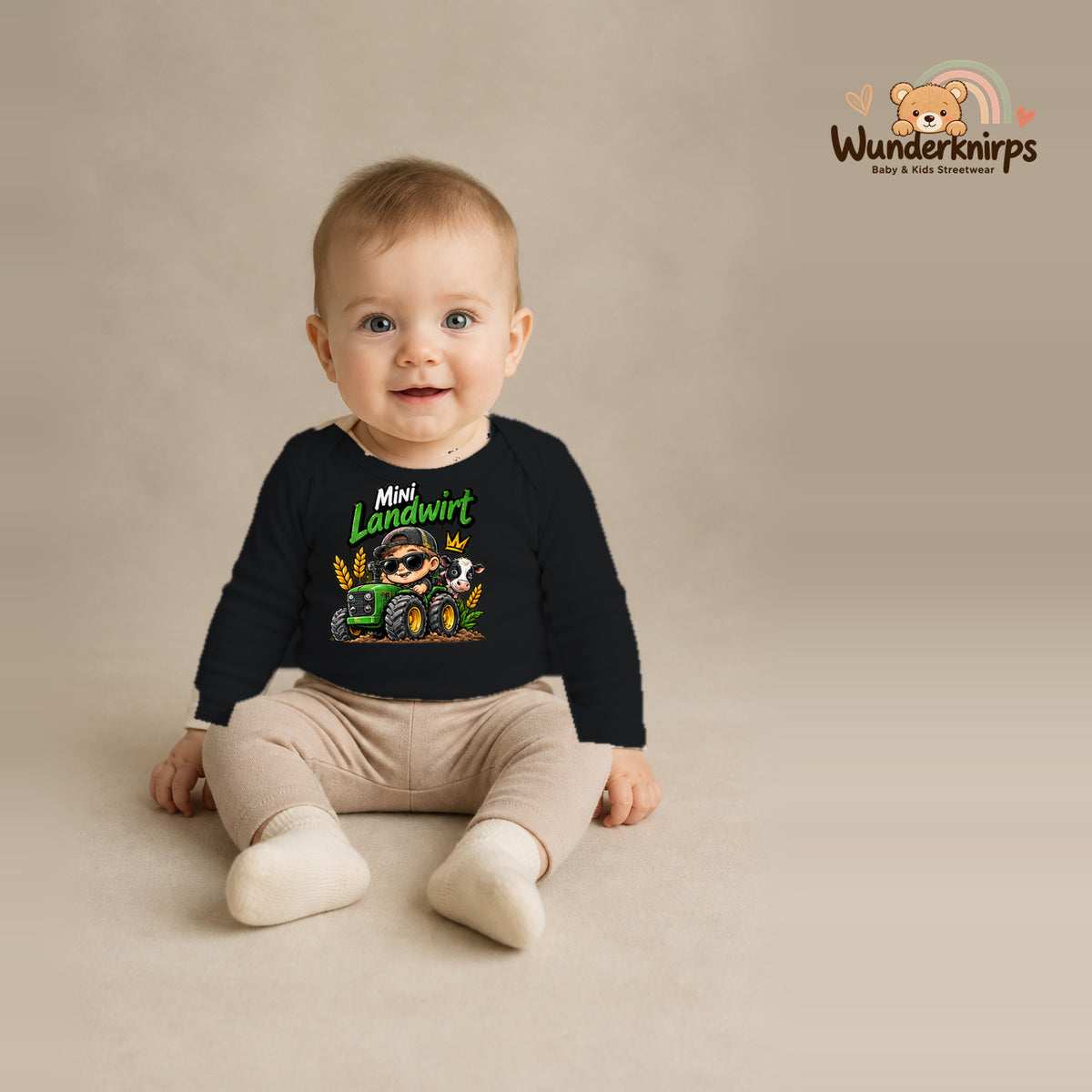 Babybody für Jungen in Schwarz mit Motiv „Mini Landwirt“, getragen von einem Kind – Wunderknirps.