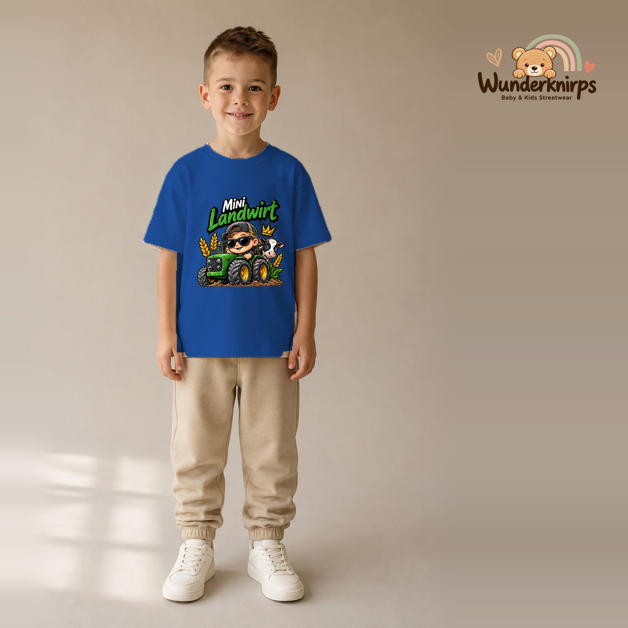 T-Shirt für Jungen in Blau mit Motiv „Mini Landwirt“, getragen von einem Kind – Wunderknirps.