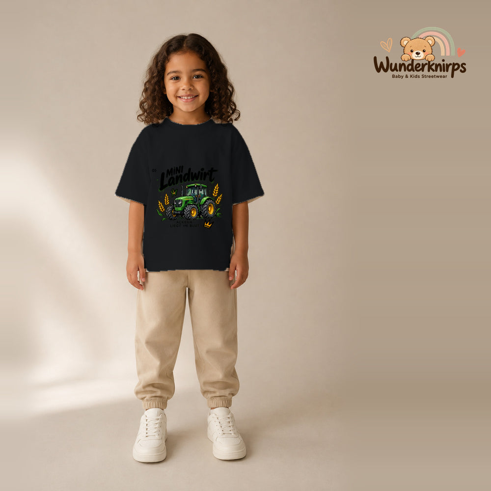 T-Shirt für Mädchen in Schwarz mit Motiv „Mini Landwirt“, getragen von einem Kind – Wunderknirps.