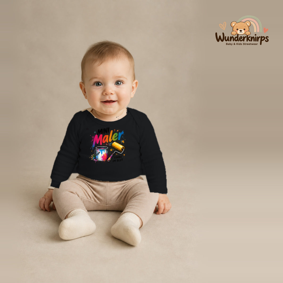Babybody für Jungen in Schwarz mit Motiv „Mini Maler“, getragen von einem Kind – Wunderknirps.