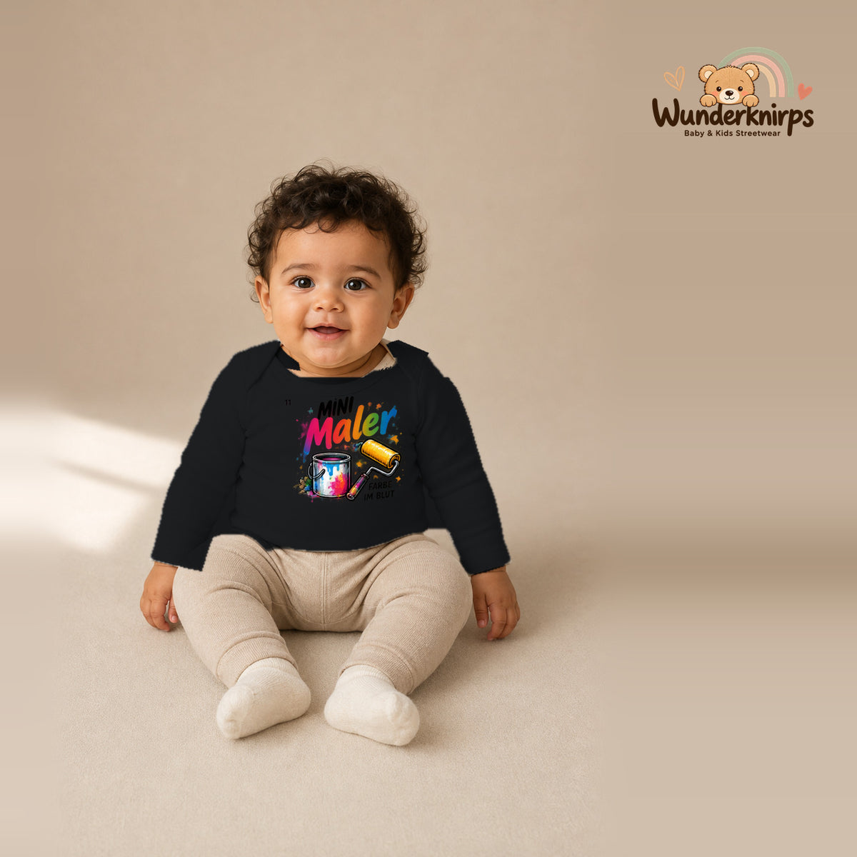 Babybody für Jungen in Schwarz mit Motiv „Mini Maler“, getragen von einem Kind – Wunderknirps.