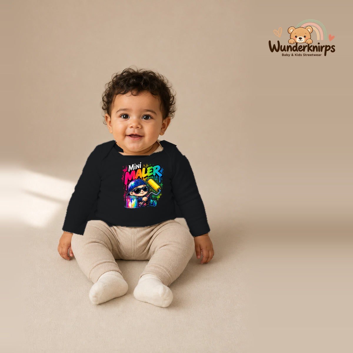 Babybody für Jungen in Schwarz mit Motiv „Mini Maler“, getragen von einem Kind – Wunderknirps.