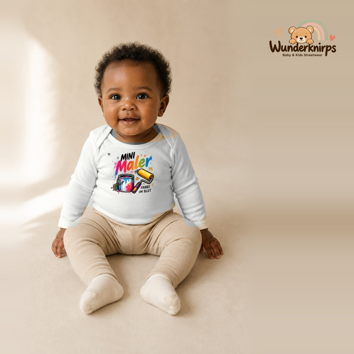Babybody für Mädchen in Weiß mit Motiv „Mini Maler“, getragen von einem Kind – Wunderknirps.