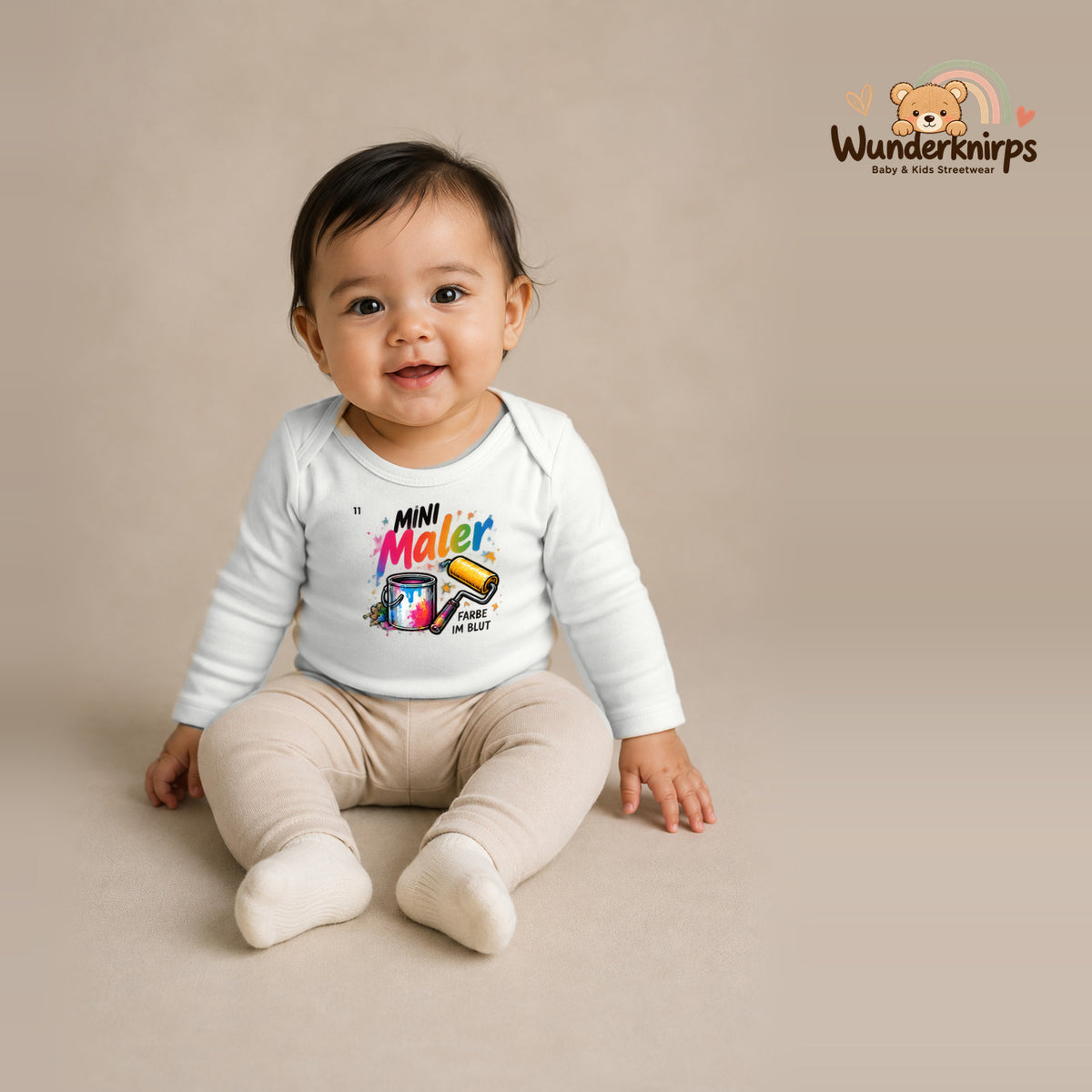 Babybody für Mädchen in Weiß mit Motiv „Mini Maler“, getragen von einem Kind – Wunderknirps.