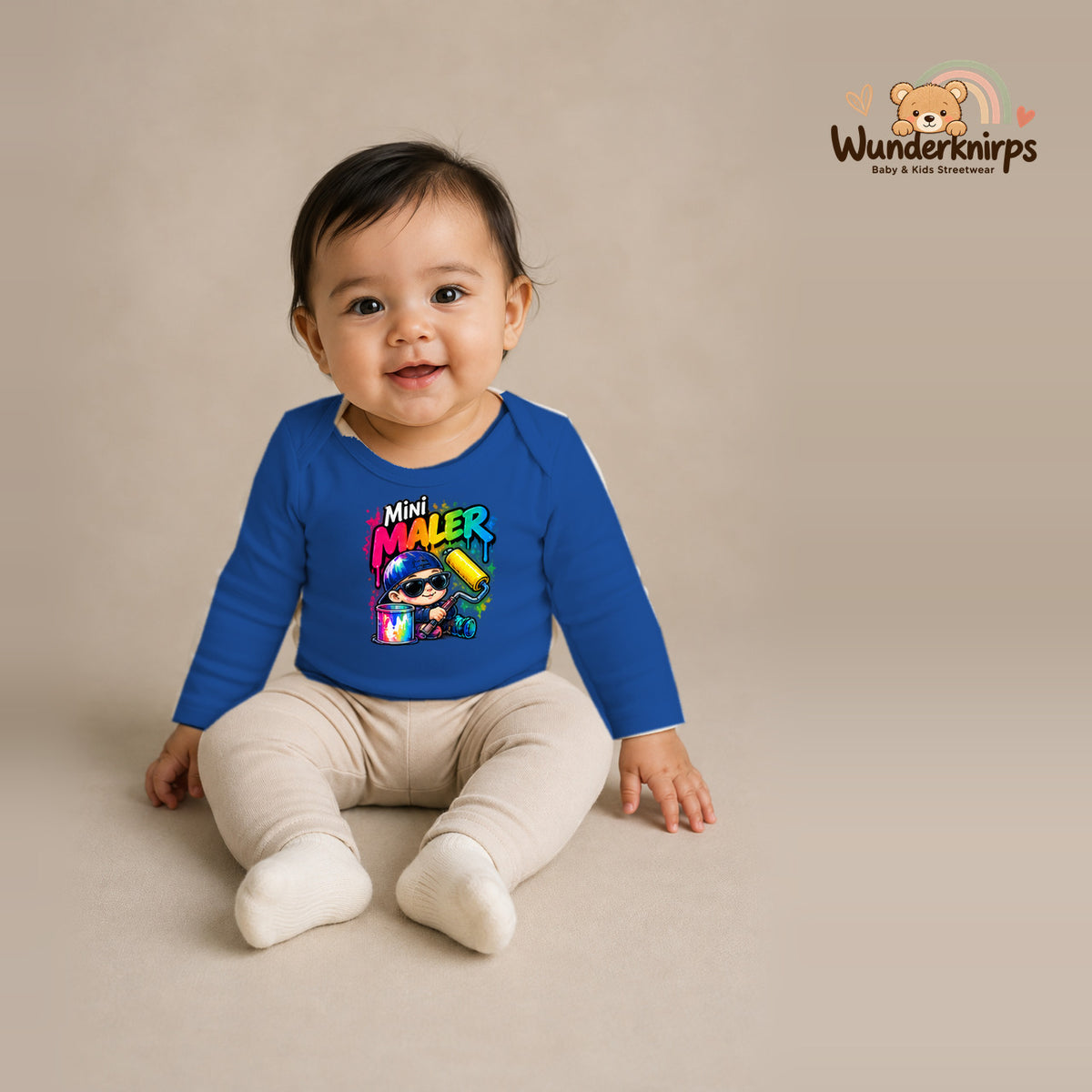 Babybody für Mädchen in Blau mit Motiv „Mini Maler“, getragen von einem Kind – Wunderknirps.