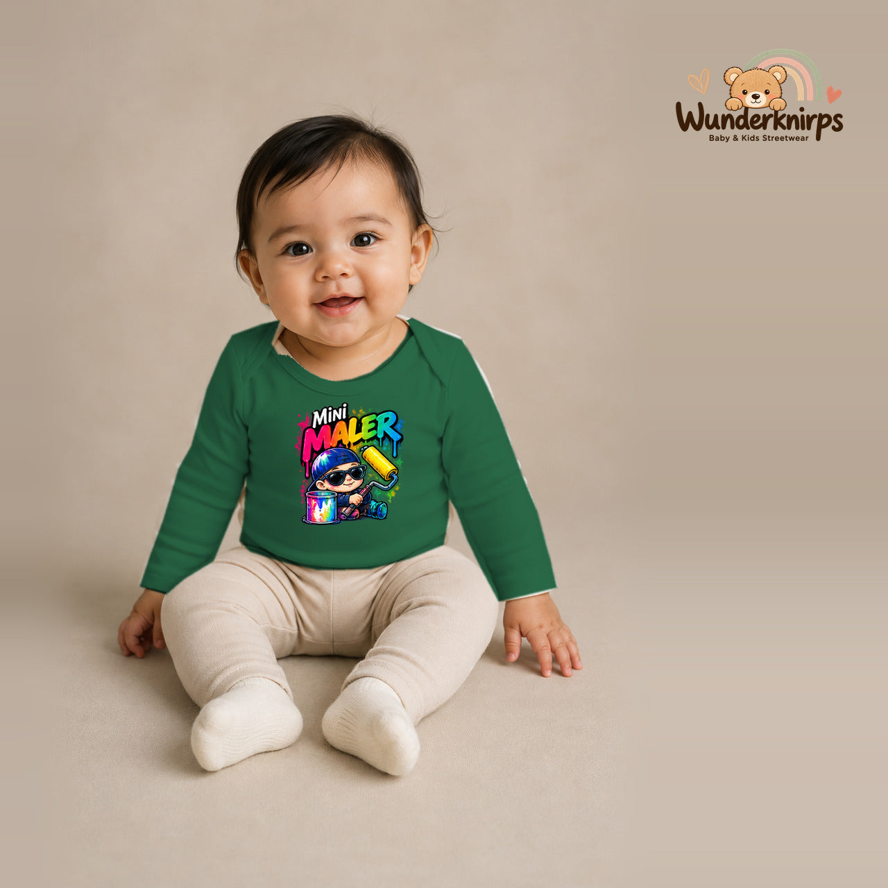 Babybody für Mädchen in Grün mit Motiv „Mini Maler“, getragen von einem Kind – Wunderknirps.