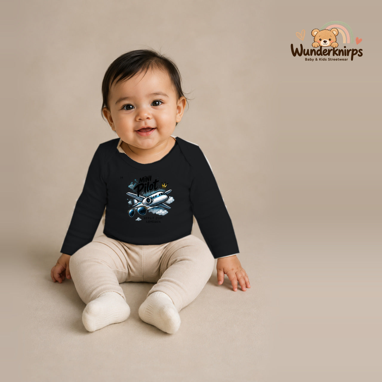 Babybody für Mädchen in Schwarz mit Motiv „Mini Pilot“, getragen von einem Kind – Wunderknirps.
