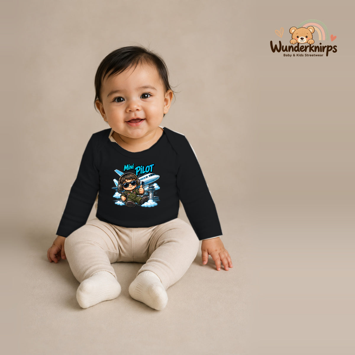 Babybody für Mädchen in Schwarz mit Motiv „Mini Pilot“, getragen von einem Kind – Wunderknirps.