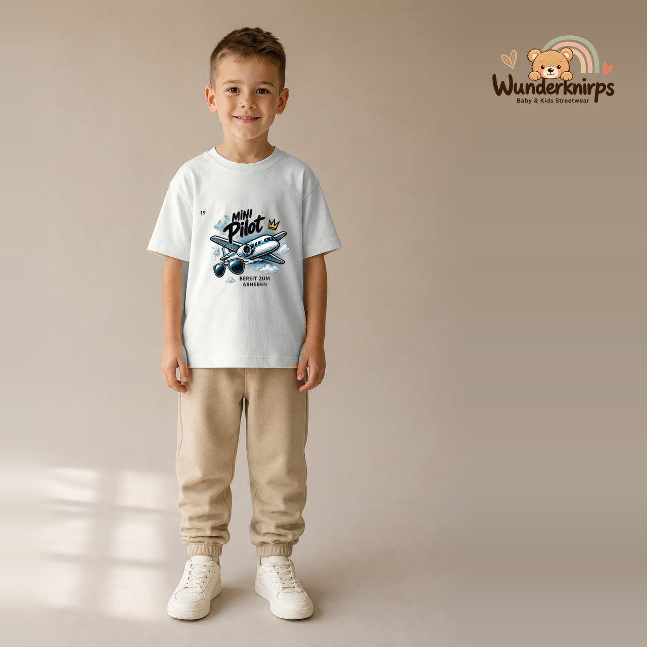 T-Shirt für Jungen in Weiß mit Motiv „Mini Pilot“, getragen von einem Kind – Wunderknirps.