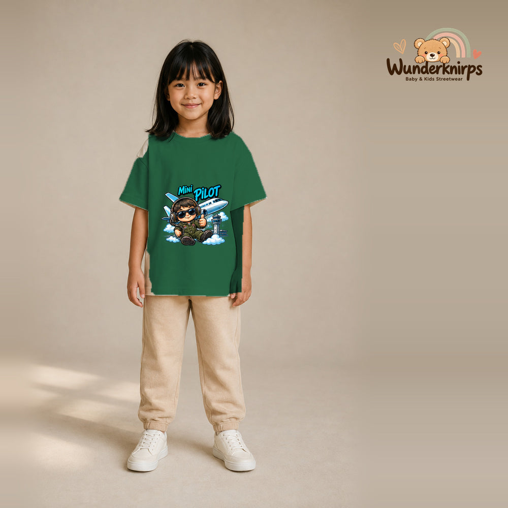 T-Shirt für Mädchen in Grün mit Motiv „Mini Pilot“, getragen von einem Kind – Wunderknirps.