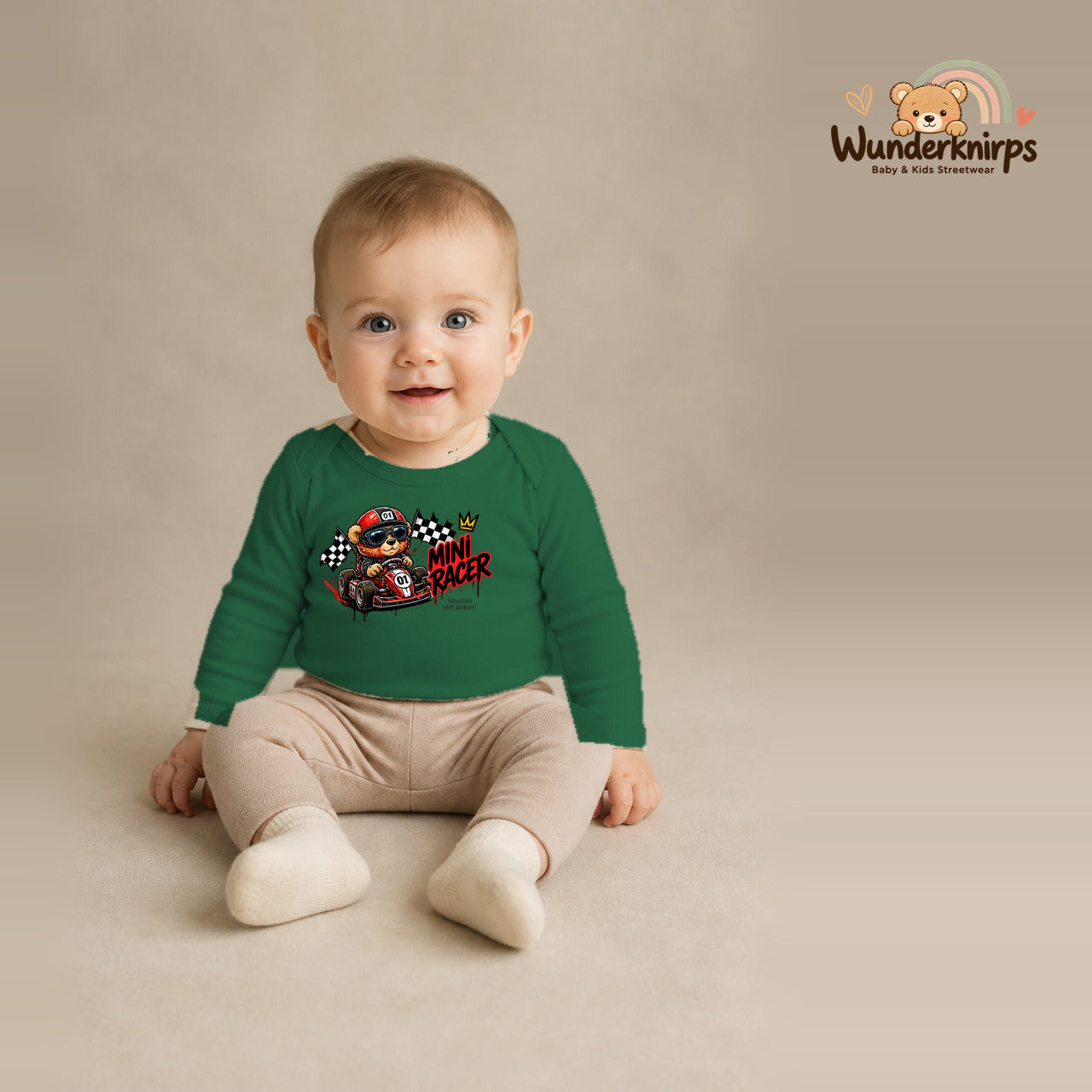 Babybody für Jungen in Grün mit Motiv „Mini Racer“, getragen von einem Kind – Wunderknirps.