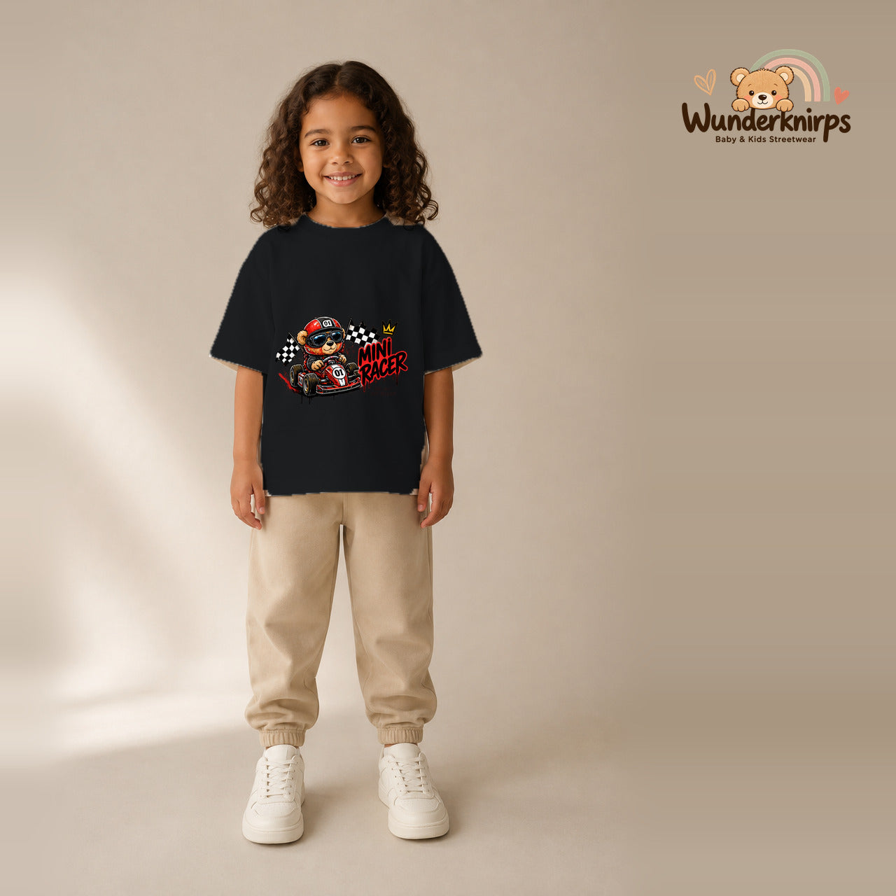 T-Shirt für Mädchen in Schwarz mit Motiv „Mini Racer“, getragen von einem Kind – Wunderknirps.