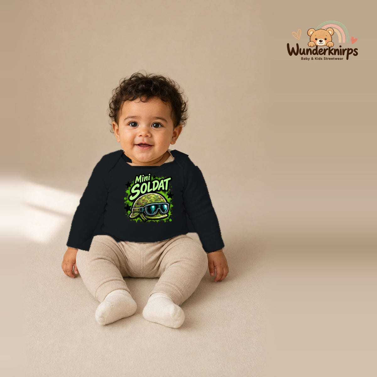 Babybody für Jungen in Schwarz mit Motiv „Mini Soldat“, getragen von einem Kind – Wunderknirps.