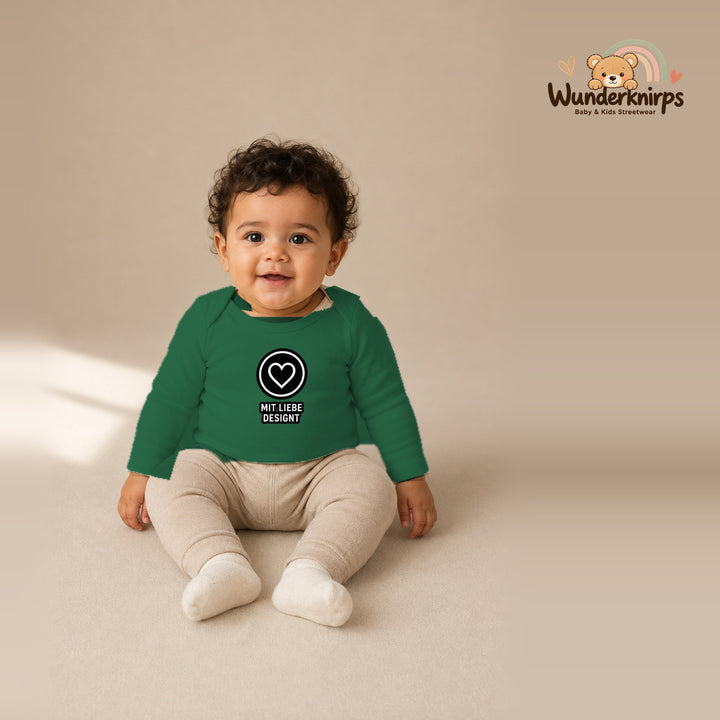 Babybody für Jungen in Grün mit Motiv „Mit Liebe designt“, getragen von einem Kind – Wunderknirps.