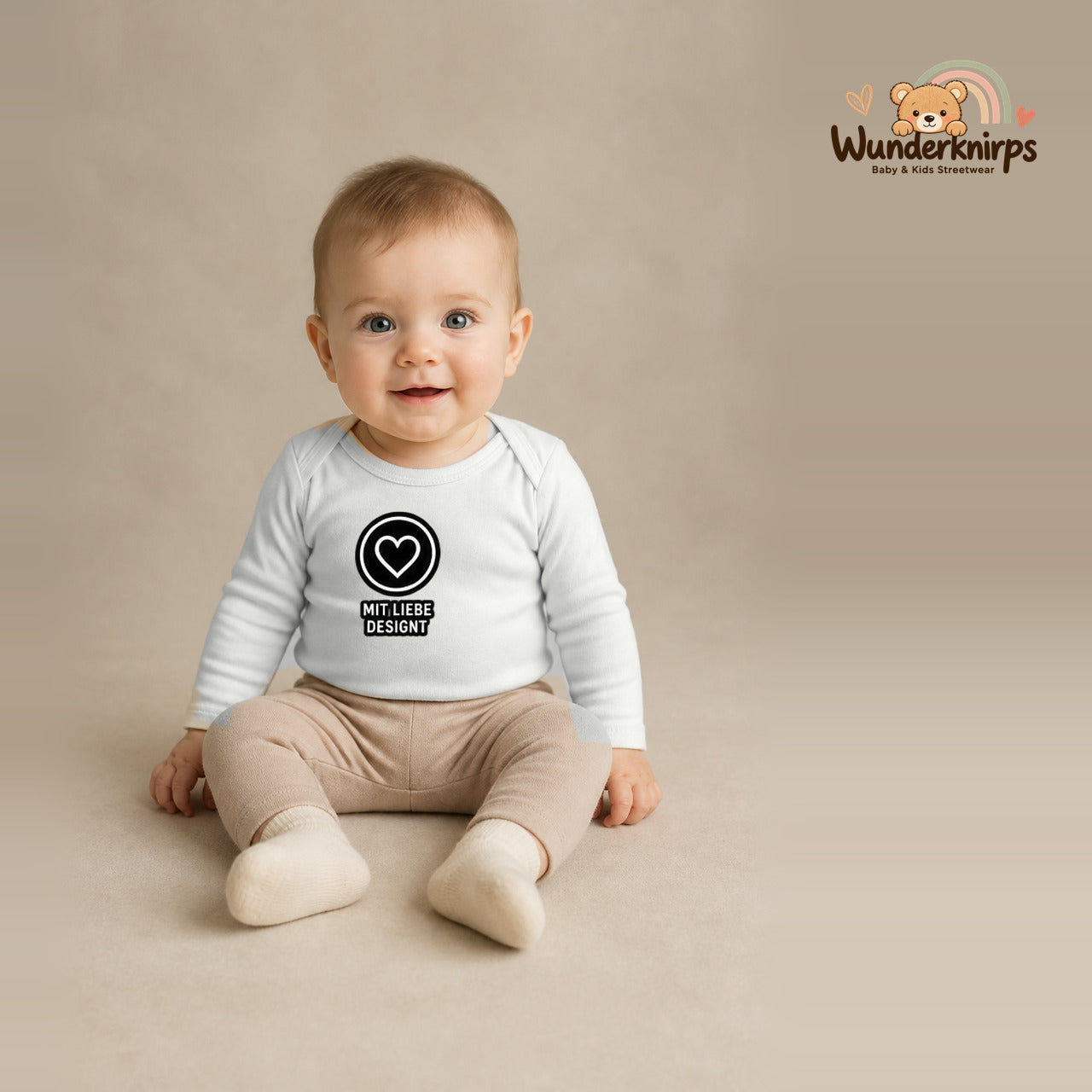 Babybody für Jungen in Weiß mit Motiv „Mit Liebe designt“, getragen von einem Kind – Wunderknirps.