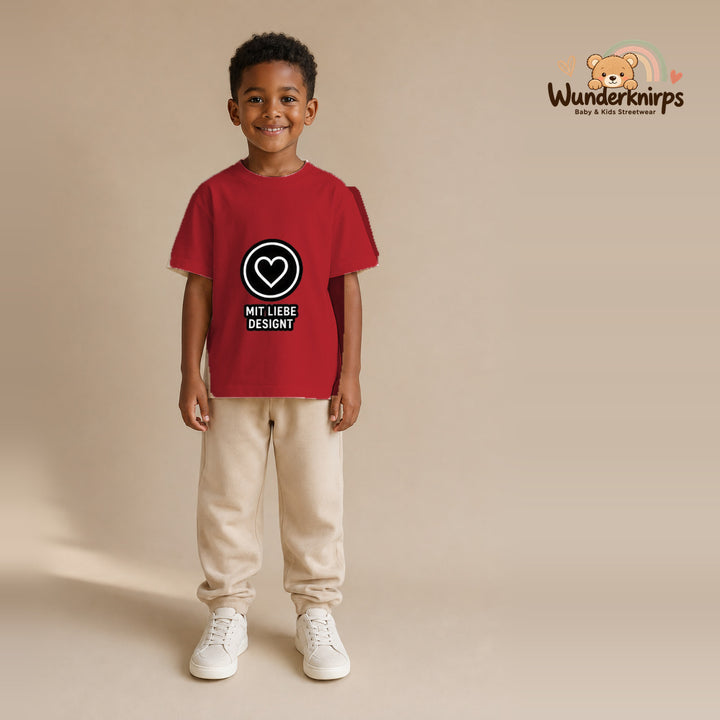 T-Shirt für Jungen in Rot mit Motiv „Mit Liebe designt“, getragen von einem Kind – Wunderknirps.