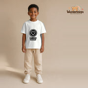 T-Shirt für Jungen in Weiß mit Motiv „Mit Liebe designt“, getragen von einem Kind – Wunderknirps.