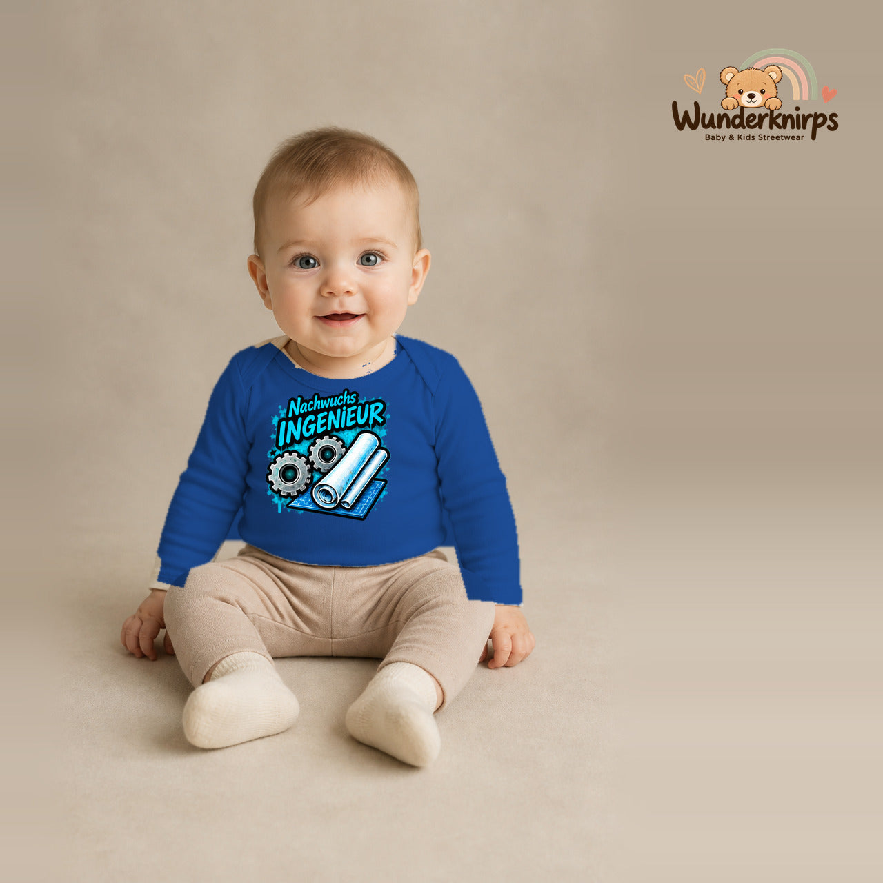 Babybody für Jungen in Blau mit Motiv „Nachwuchs Ingenieur“, getragen von einem Kind – Wunderknirps.