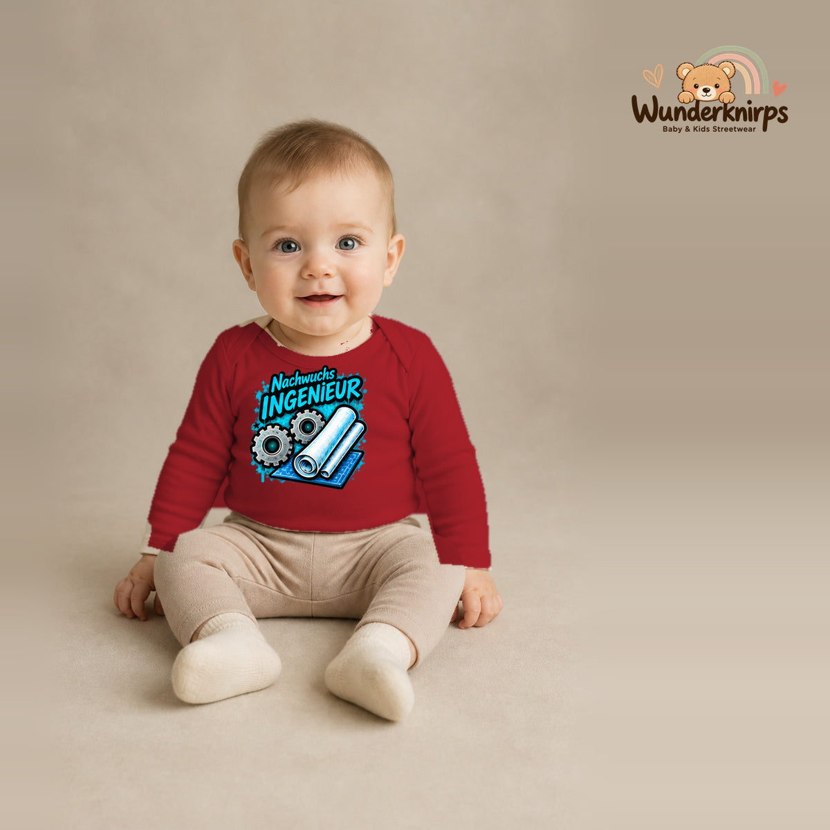 Babybody für Jungen in Rot mit Motiv „Nachwuchs Ingenieur“, getragen von einem Kind – Wunderknirps.