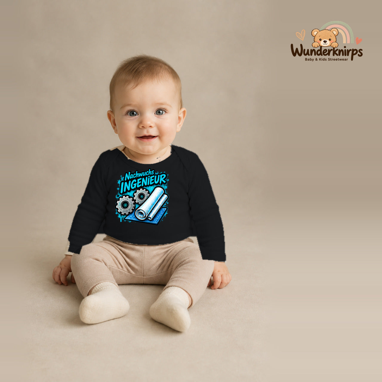 Babybody für Jungen in Schwarz mit Motiv „Nachwuchs Ingenieur“, getragen von einem Kind – Wunderknirps.