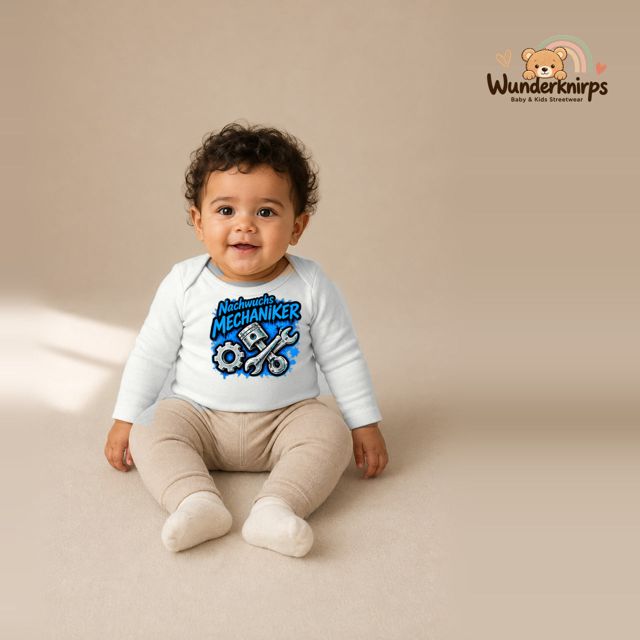 Babybody für Jungen in Weiß mit Motiv „Nachwuchs Mechaniker“, getragen von einem Kind – Wunderknirps.