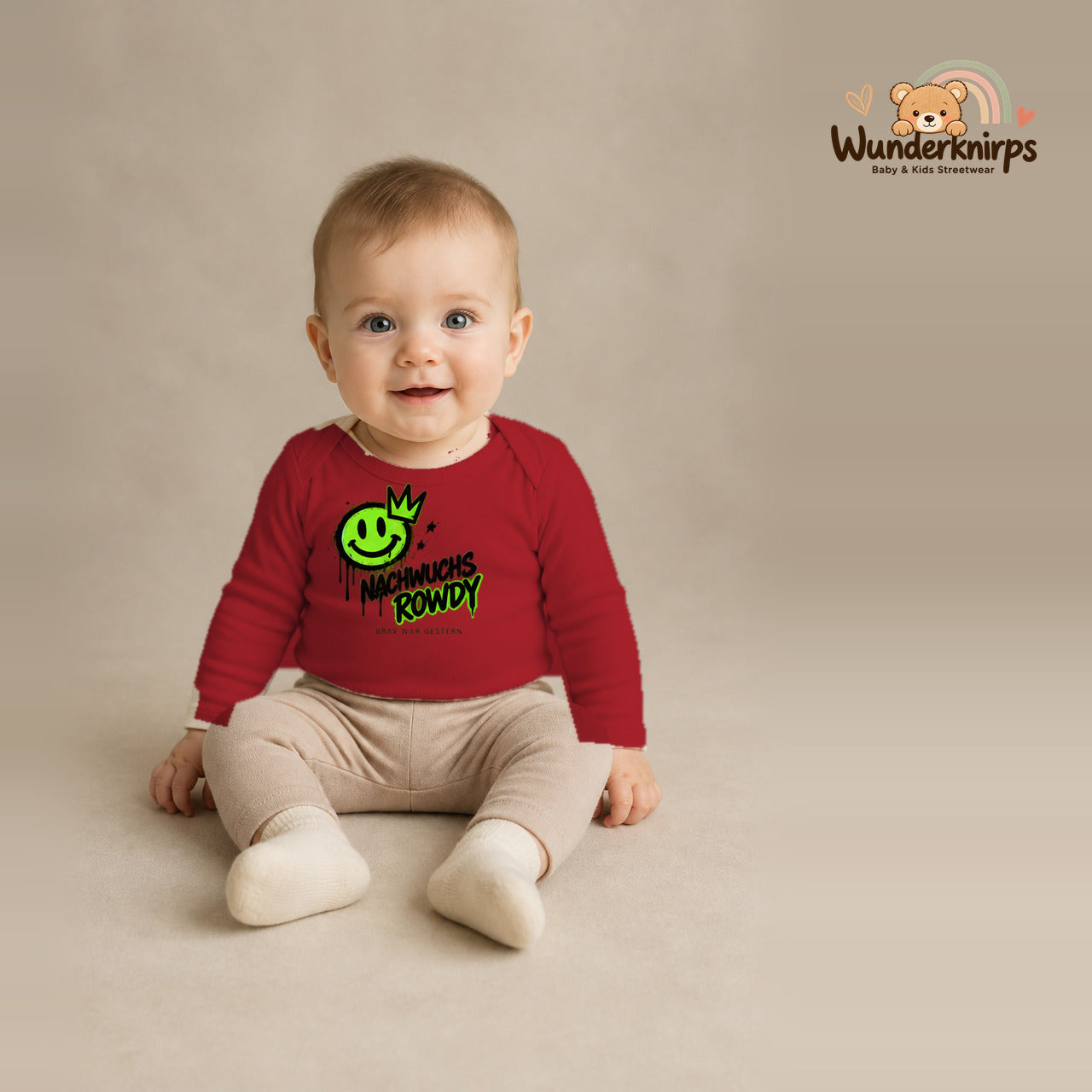 Babybody für Jungen in Rot mit Motiv „Nachwuchs Rowdy“, getragen von einem Kind – Wunderknirps.