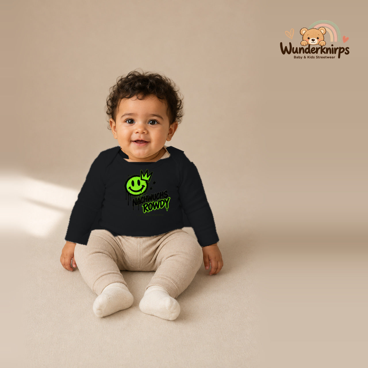 Babybody für Jungen in Schwarz mit Motiv „Nachwuchs Rowdy“, getragen von einem Kind – Wunderknirps.
