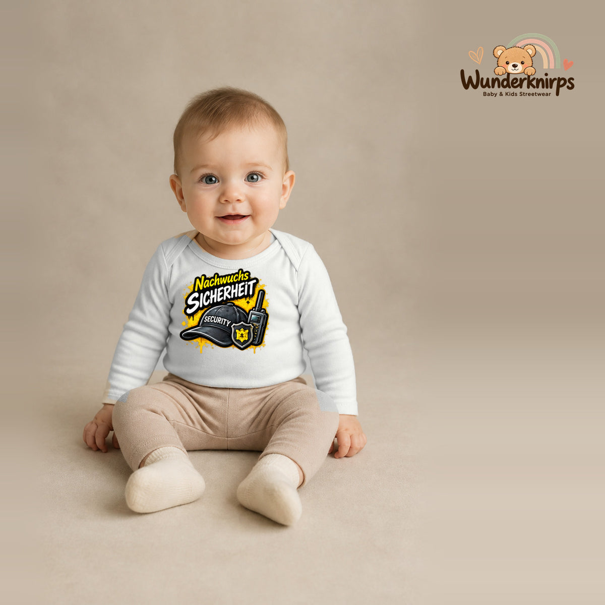 Babybody für Jungen in Weiß mit Motiv „Nachwuchs Sicherheit“, getragen von einem Kind – Wunderknirps.