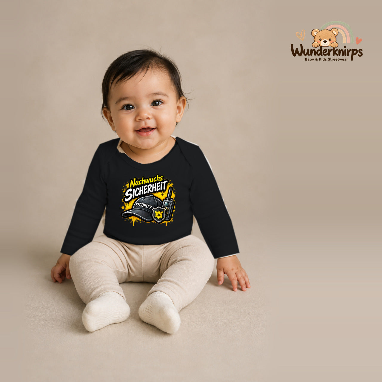Babybody für Mädchen in Schwarz mit Motiv „Nachwuchs Sicherheit“, getragen von einem Kind – Wunderknirps.