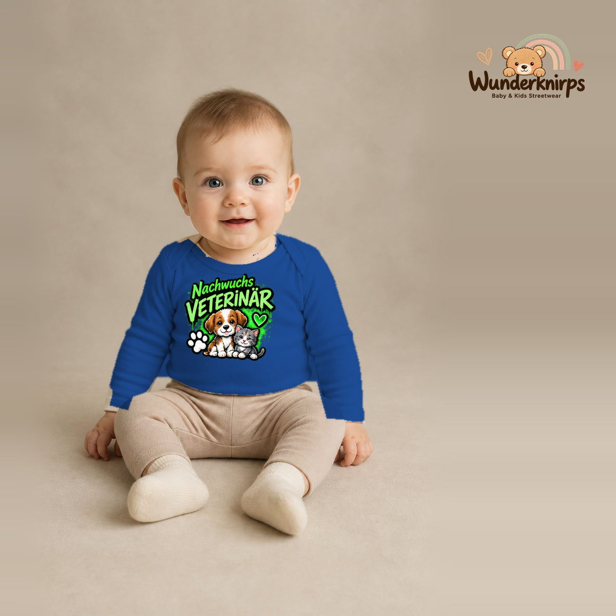 Babybody für Jungen in Blau mit Motiv „Nachwuchs Veterinär“, getragen von einem Kind – Wunderknirps.