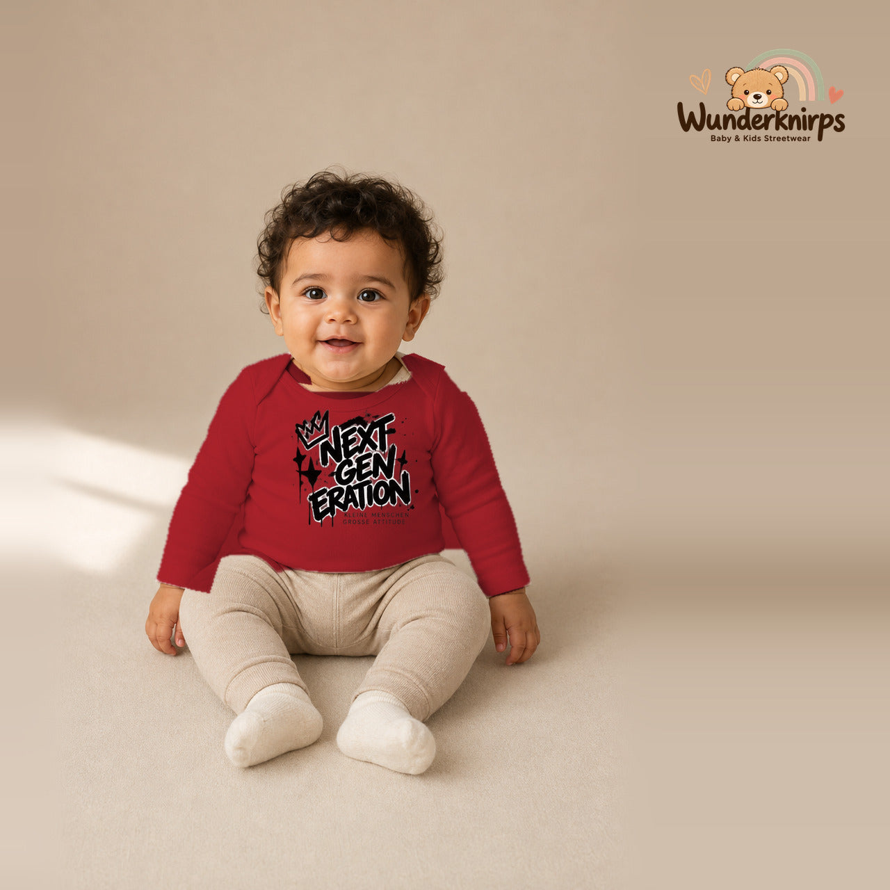 Babybody für Jungen in Rot mit Motiv „Next Generation“, getragen von einem Kind – Wunderknirps.