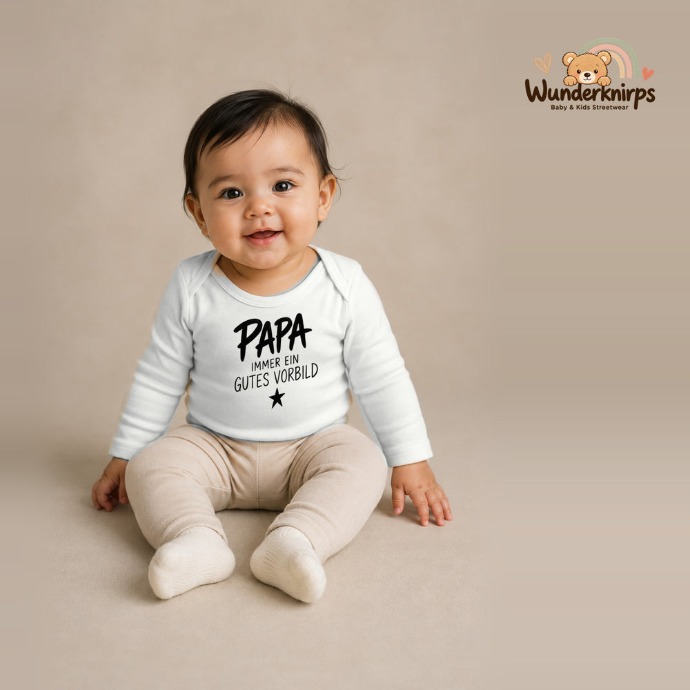 Babybody für Mädchen in Weiß mit Motiv „Papa gutes Vorbild“, getragen von einem Kind – Wunderknirps.
