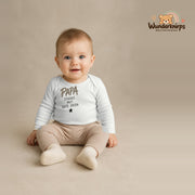 Babybody für Jungen in Weiß mit Motiv „Papa Stärke“, getragen von einem Kind – Wunderknirps.
