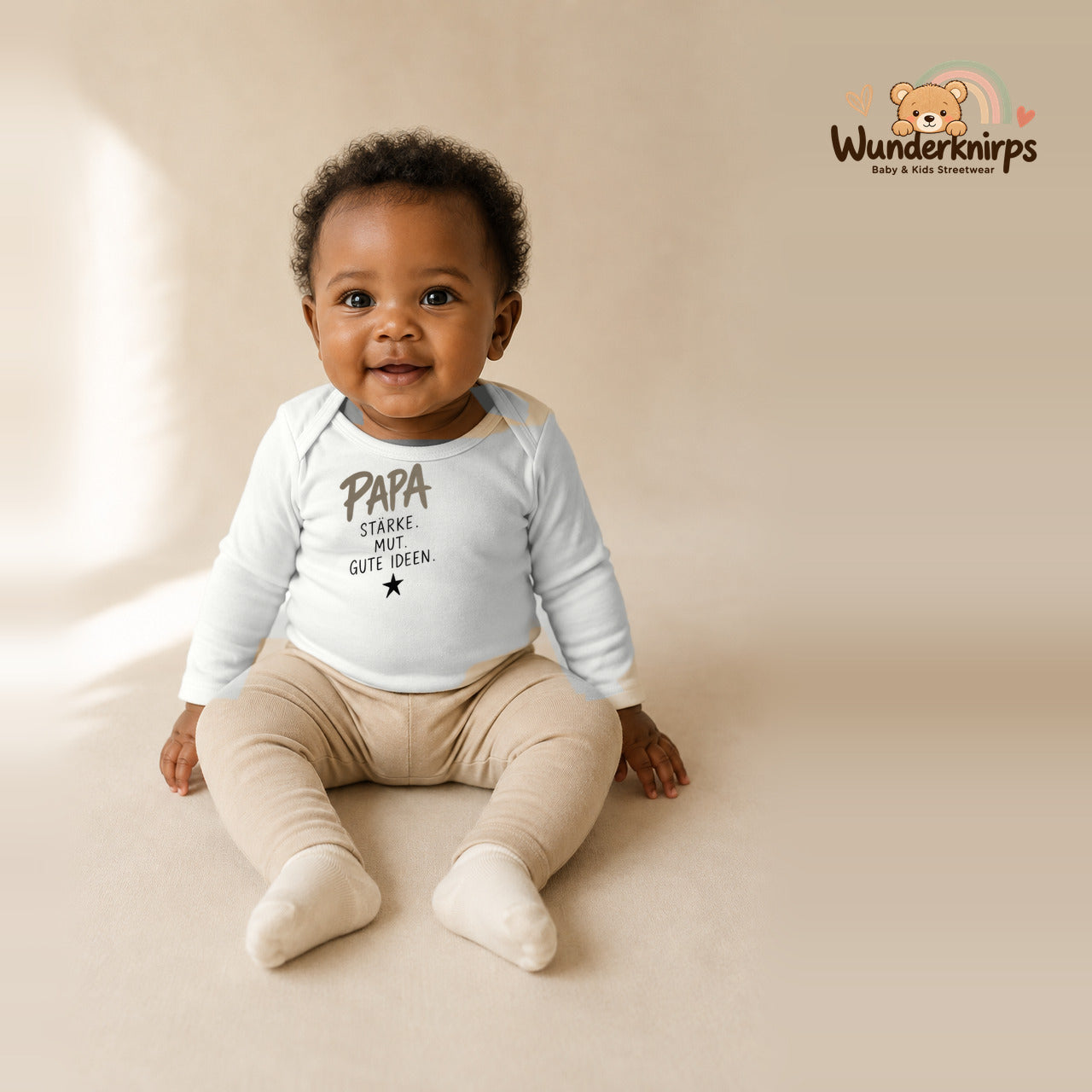 Babybody für Mädchen in Weiß mit Motiv „Papa Stärke“, getragen von einem Kind – Wunderknirps.